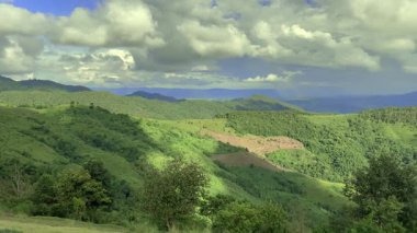 Asya 'da gündüz vakti dağ manzarasının yavaş çekimleri. Bereketli yeşil orman, doğal manzara, huzurlu atmosfer, insan yok. Seyahat, doğa, belgesel, rahatlama ve çevresel arka plan videoları için ideal.