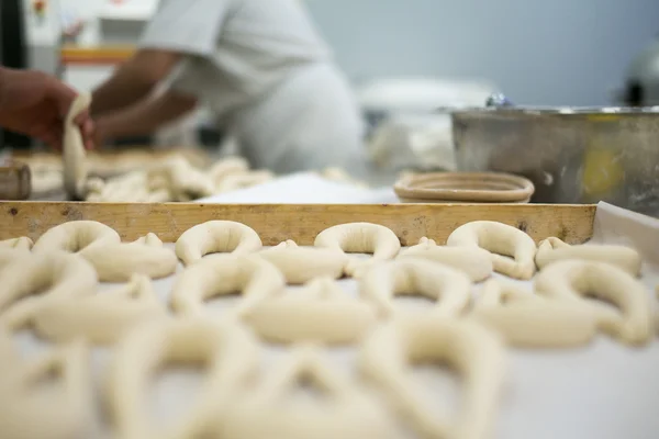 Panettieri che preparano Pretzel fresco Pasta sul vassoio — Foto Stock