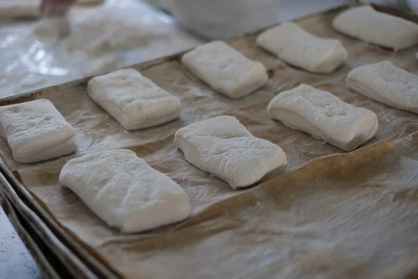 Baker Colocación de pan crudo Ciabatta en bandeja — Foto de Stock