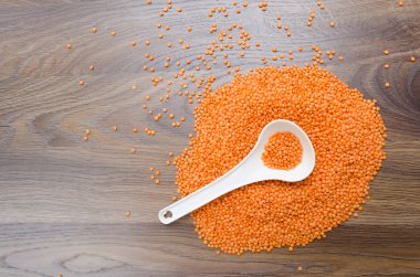 Beyaz kaşık içinde portakal mercimek