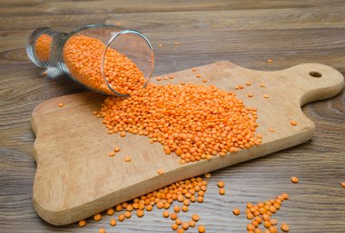 Ahşap kesme tahtası üzerinde kırmızı mercimek