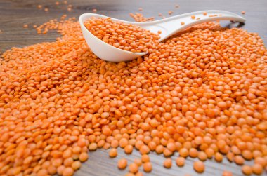 Beyaz kaşık içinde portakal mercimek