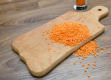 Ahşap kesme tahtası üzerinde kuru kırmızı mercimek