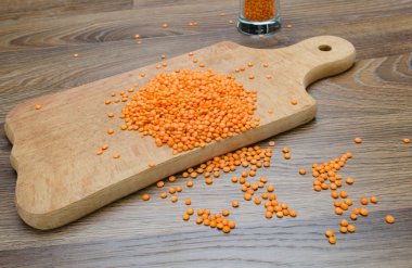 Ahşap kesme tahtası üzerinde kuru kırmızı mercimek