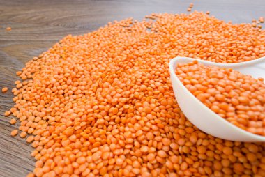 Beyaz kaşık içinde portakal mercimek