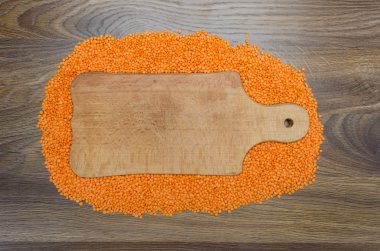 Ahşap kesme tahtası çevresinde kırmızı mercimek