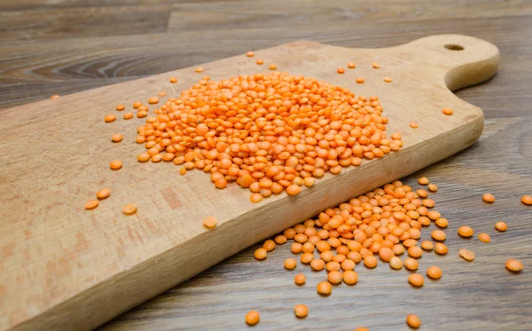 Ahşap kesme tahtası üzerinde kuru kırmızı mercimek