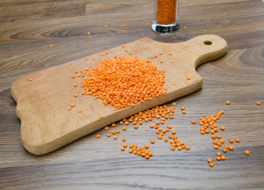 Ahşap kesme tahtası üzerinde kuru kırmızı mercimek