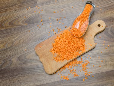 Ahşap kesme tahtası üzerinde kırmızı mercimek