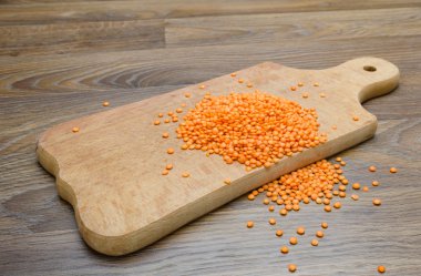 Ahşap kesme tahtası üzerinde kuru kırmızı mercimek