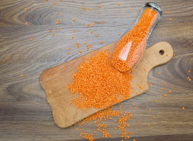 Ahşap kesme tahtası üzerinde kırmızı mercimek