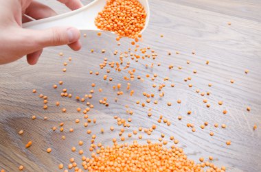 Turuncu mercimek dökülen beyaz bir kaşık