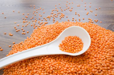 Beyaz kaşık içinde portakal mercimek