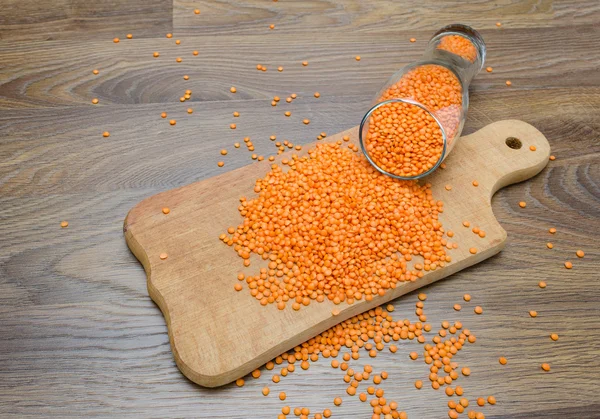 Ahşap kesme tahtası üzerinde kırmızı mercimek