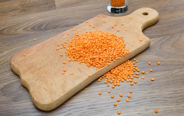 Ahşap kesme tahtası üzerinde kuru kırmızı mercimek