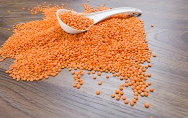 Beyaz kaşık içinde portakal mercimek