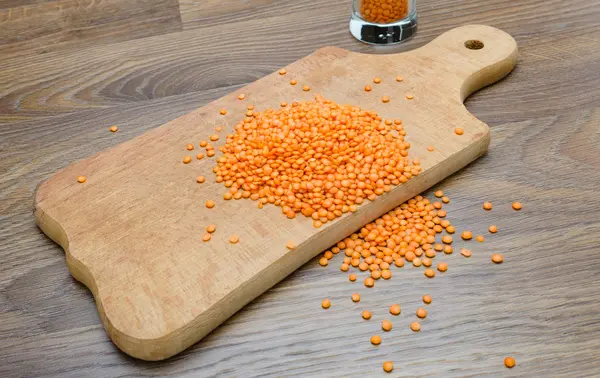 Ahşap kesme tahtası üzerinde kuru kırmızı mercimek