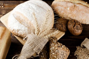 Spikelets Ahşap doğrama tahtası üzerinde buğday ile taze ekmek natürmort.