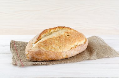 Beyaz ekmek üzerinde çul yalan. Beyaz ahşap masa.