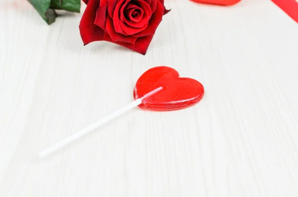 棒棒糖红色的心与玫瑰在白色的木桌上 情人节 — 图库照片