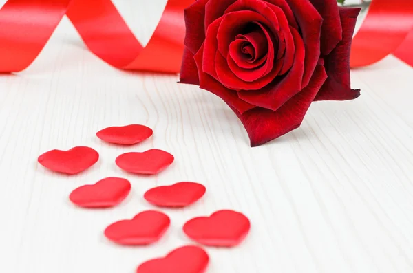 Große Frische Rose Auf Einem Holztisch Mit Roten Herzen lizenzfreie Stockfotos