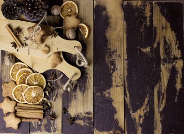 Noel arkaplanı ev yapımı zencefilli kurabiye ve siyah ahşap masada baharatlar. Kutlama yemekleri, Yeni Yıl