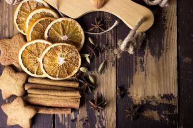 Noel arkaplanı ev yapımı zencefilli kurabiye ve siyah ahşap masada baharatlar. Kutlama yemekleri, Yeni Yıl