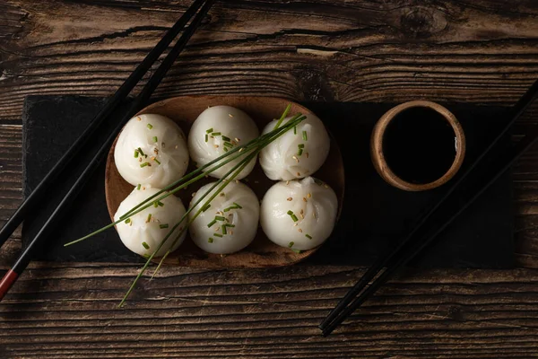 Cerdo al vapor y dim sum de gambas sobre piedra pizarra sobre mesa de madera — Foto de Stock