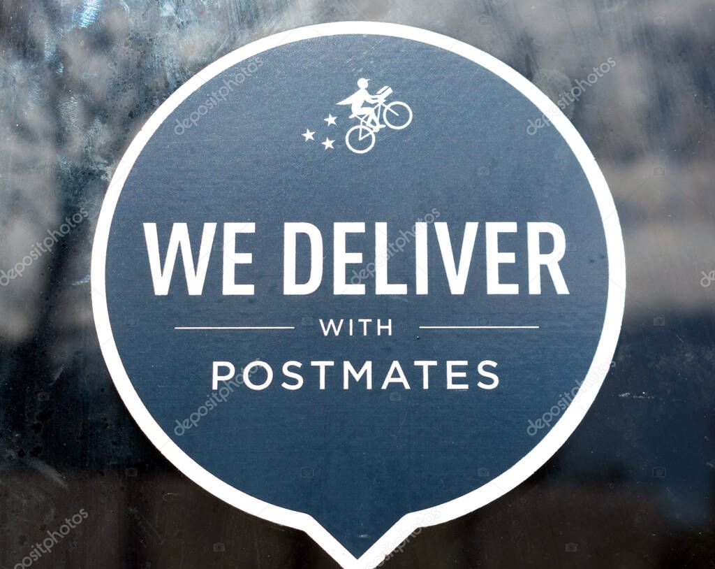 Close up. Postmates black sticker decal advertising delivery service available through Postmates goods delivery service - San Jose, California, USA - 2020