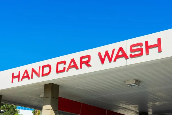 Hand Car Wash sign on canopy structure of facility used to clean motor vehicles