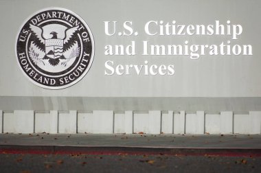 ABD Vatandaşlık ve Göçmenlik Hizmetleri imzası, USCIS saha ofisinde beton duvarda logo. USCIS, ABD İç Güvenlik Bakanlığı 'nın San Jose, Kaliforniya, ABD - 2021