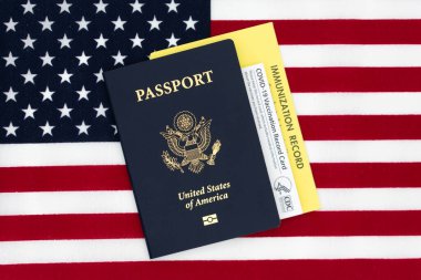 COVID-19 aşı resmi CDC kayıt kartı, aşı kartı ve ABD 'nin ABD Bayrağı hakkındaki pasaport kitabı - San Jose, California, ABD - 2021