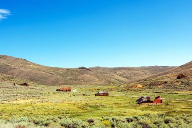 Çöl manzarası ve Bodie hayalet kasabasındaki terk edilmiş ahşap evler.