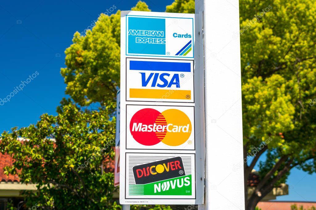 Vintage American Express Cards, VISA, MasterCard, Discover Novus payment options advertisement on the outdoor sign near business location - San Jose, California, USA - 2020