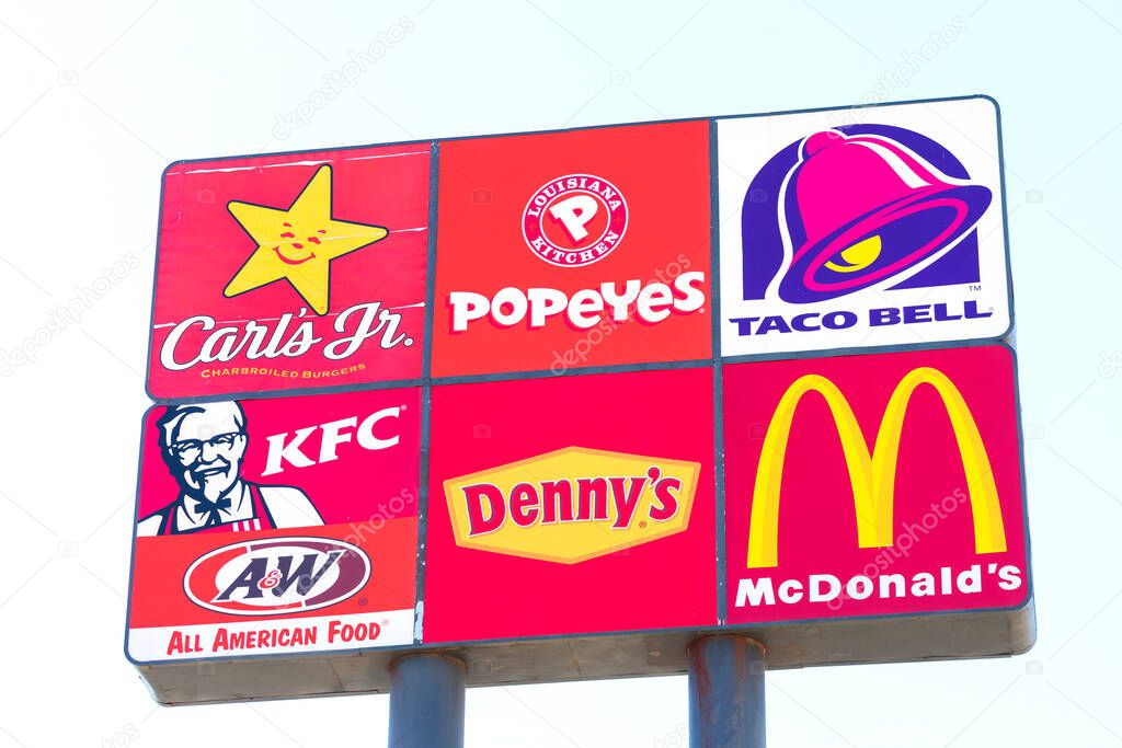 Carl's Jr., Popeyes, Taco Bell, KFC, Denny s and McDonald's fast food restaurants logos on road sign. Interstate highway advertising sign. - Stockton, California, USA - 2021