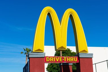 McDonald 's Altın Kemer sembolü. Fast food restoranının mavi gökyüzünün altındaki tabelasına doğru sür. Yakın plan - Santa Clara, California, ABD - 2021