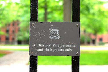 Yale Özel Kalemi 'ne yetkilendirilmiş ve konukların Yale Üniversitesi arması altında sadece uyarı levhası var. Bulanık yeşil park manzarası geçmişi - New Haven, Connecticut, ABD - 2021