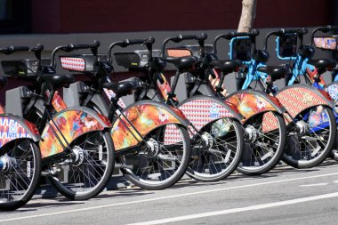 Group of colorful Lyft electric assist Bay Wheels classic bikes parked in a row at outdoor bicycle station. - San Francisco, California, USA - 2021