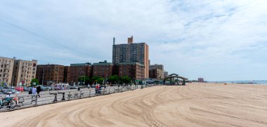Panoramik manzara ahşap Riegelmann Boardwalk, yüksek binalar ve Brighton Sahili - Brooklyn, New York, ABD - Haziran 2021