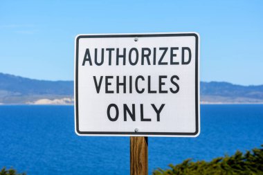 Yetkili Araçlar Sadece Yol İşareti. Körfezin sakin suyu ve kıyı şeridi uzaklıktan görülebilir..