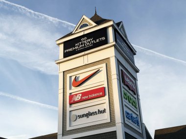 Modern outlet alışveriş merkezi pilon yapısı Kittery Premium Outlets, Nike, New Balance ve Sunglass Hut perakende satış panelleri - Kittery, Maine, USA - 2 Ekim 2025