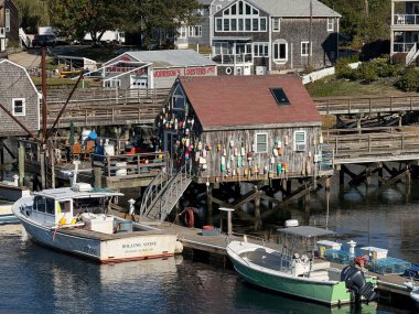 Istakoz kulübesi, Porsuk Adası limanındaki ahşap rıhtımdaki balıkçı teknelerinin yanında renkli şamandıralarla süslenmiş.