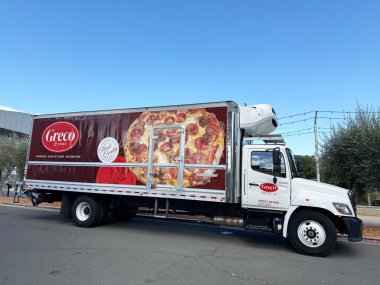 Greco ve Oğulları logosu olan bir teslimat kamyonu ve şehir caddesi boyunca park edilmiş büyük bir pizza reklamı. Yan Bakış - Napa, California, ABD - 8 Eylül 2025