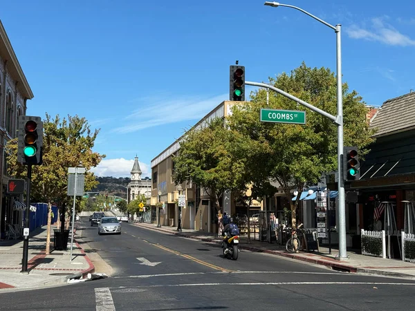 Coombs Caddesi kavşağındaki şehir manzarası yerel dükkanlar, yayalar ve tepeleri ve saat kulesi olan araçları gösteriyor - Napa, California, ABD - 8 Eylül 2025