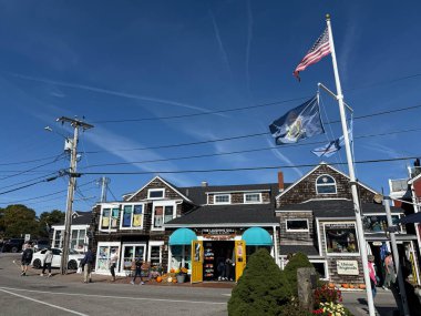 Amerikan bayrağı ve Maine eyaleti pankartı The Laughing Gull mağazalarının üzerinde Perkins Cove Village Caddesi boyunca dalgalanmaktadır.