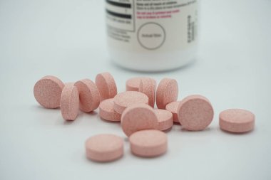 İlaç ilaç vitamin hapları şişeden dökülmüş, gri arka planda. Metin için alanı kopyala