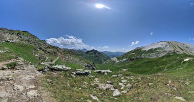 Güneşli bir günde Alp dağlarının manzarası. Rocky tepeleri. Çayırlar, yürüyüş yolları.