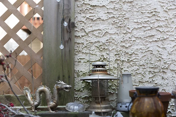Porch rustic decoration over a wall with lattice. Decorative pieces of lamps and dragon on a deck