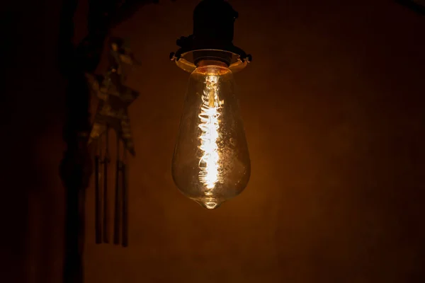 Incandescent bulb. Vintage hanging Edison light bulb in a dark, spooky room