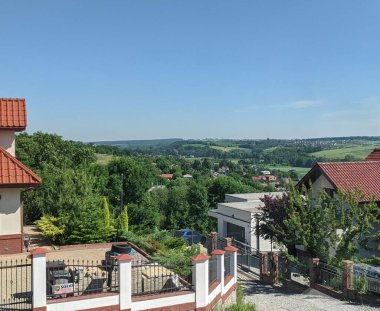 Michalowice, Polonya - 30 Haziran 2021: Polonya 'nın Krakow banliyölerinin bir tepeden görünüşü. Uzaktan görülen evler ve ağaçlar